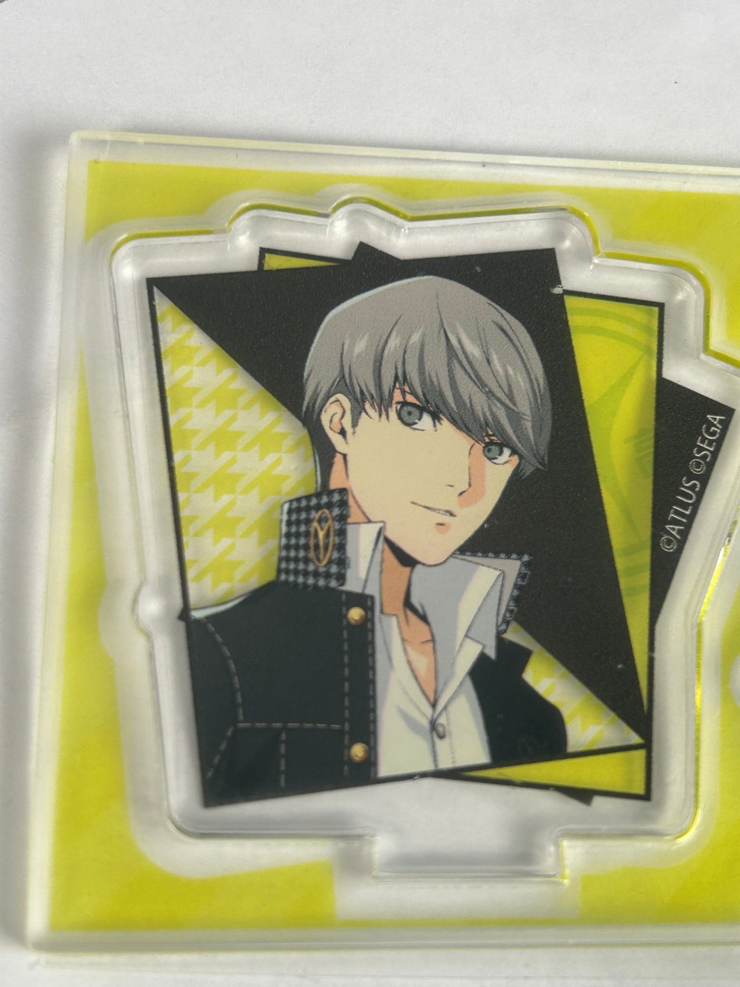 Yu Narukami on a yellow background acrylic stand smiling to the viewer for the Persona Series acrylic collection page