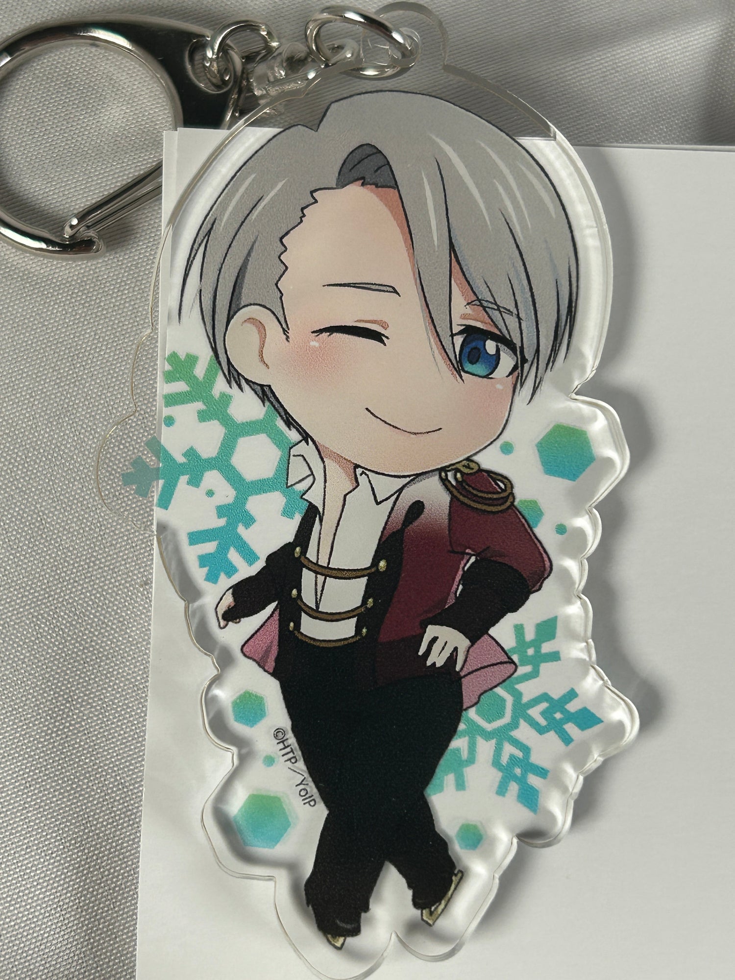 Victor Nikiforov in a fancy dress outfit on an acrylic keychain with snowflakes background for the Yuri on Ice Collections Page